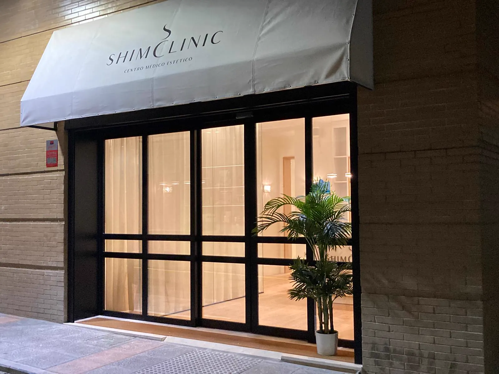 Entrada de Shim Clinic en Ceuta, con la recepción iluminada